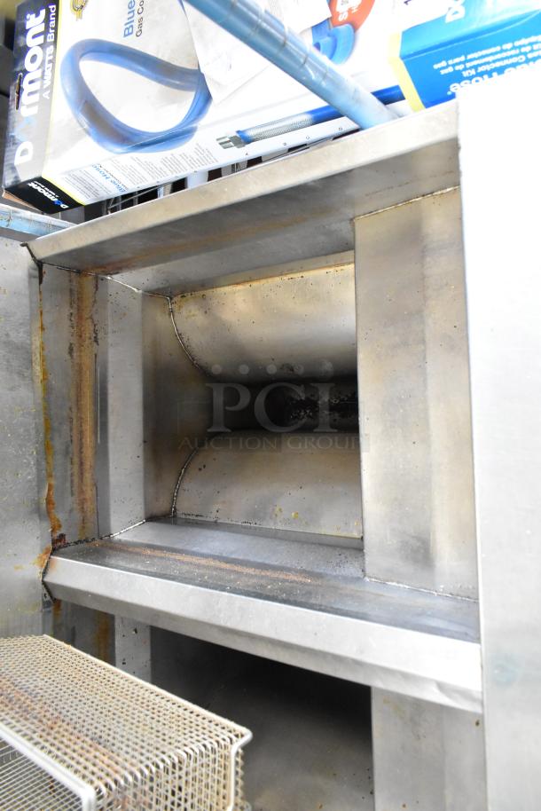 Frymaster FM245ESC stainless steel two-bay deep fat fryer with filtration system, dumping station, and four fry baskets on casters.