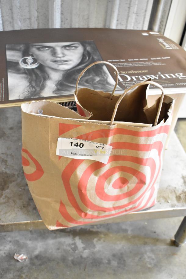 Lot of art supplies including Strathmore drawing pad, acrylic paints, brushes; items in paper bag with auction tag "140".