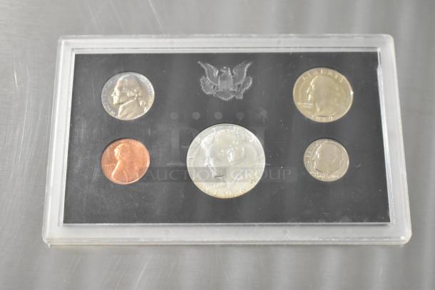 1969 U.S. proof coin set in plastic case, featuring a Kennedy half dollar, Washington quarter, Roosevelt dime, Jefferson nickel, and Lincoln penny.