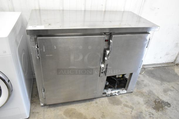 Universal Coolers SC42 stainless steel undercounter cooler, two doors, some wear, 115 volts, 1 phase, model tag visible.