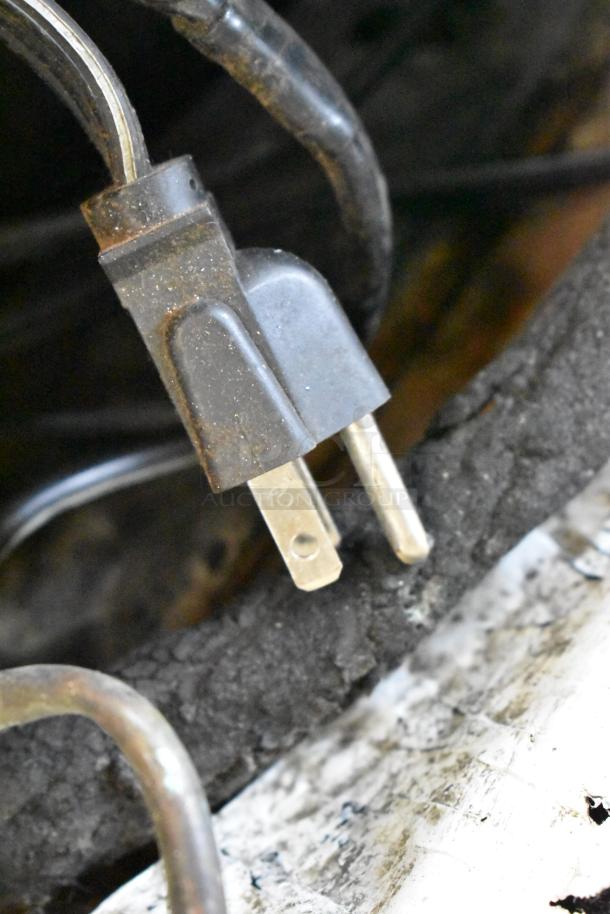 A two-prong plug with visible wear, likely part of the Universal Coolers SC42 undercounter cooler, model not directly shown.