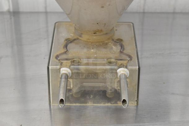 Clear poly pastry filler hopper with two spouts, showing signs of use. No lid. Ideal for bakery or pastry applications.