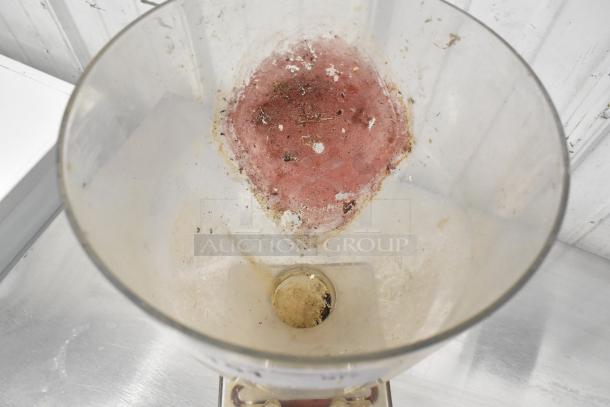 Clear poly pastry filler hopper with two spouts, without lid. Visible wear and residue inside, suitable for baking applications.