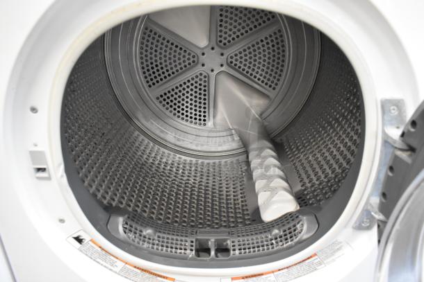 Whirlpool metal front load dryer interior, showcasing a clean, well-maintained drum with visible safety labels.
