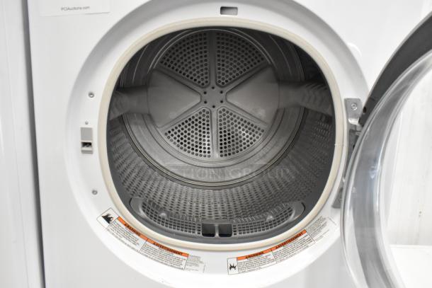 Whirlpool metal front load dryer with open door, showcasing spacious stainless steel drum and safety warning labels.