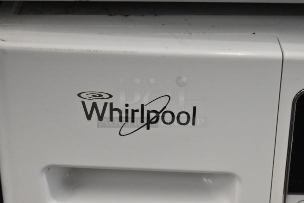 Whirlpool front load dryer, metal exterior, brand logo visible, slight surface scuffs, auction item.