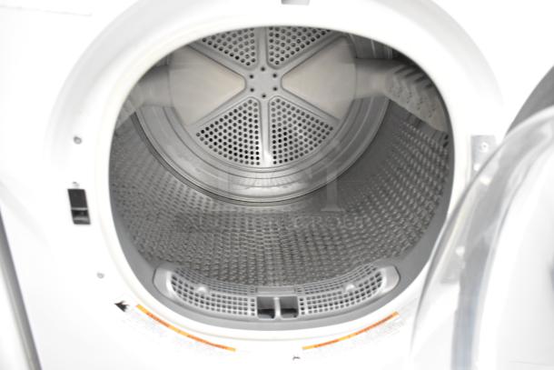Whirlpool front load dryer interior, silver metal drum, clean condition, visible air vent grill.