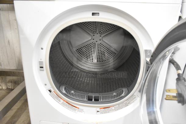 Whirlpool front load dryer, metal interior, white exterior, open door view showing drum. Includes warning labels.