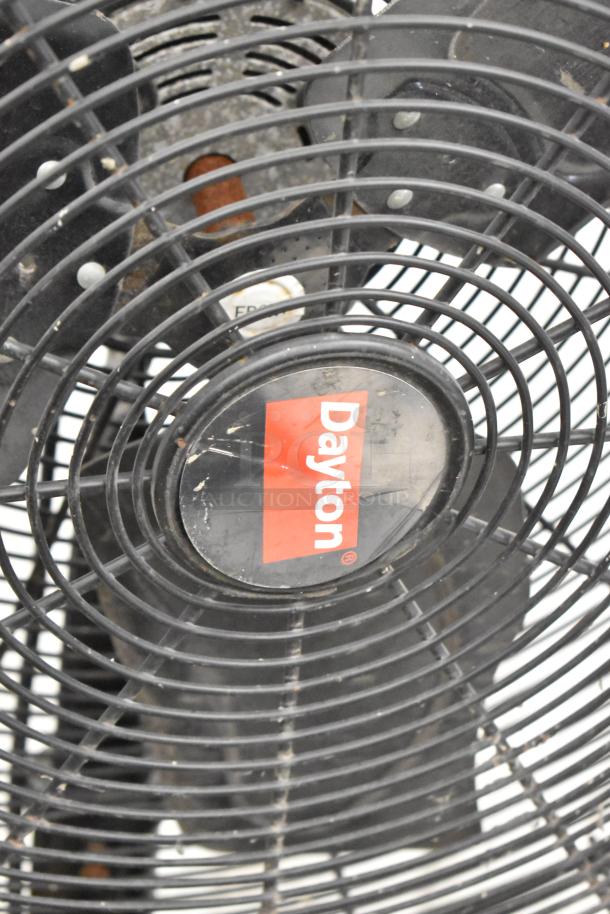 Dayton 2LY97B black metal floor fan with visible logo. 120 volts, 1 phase. Appears in used condition.