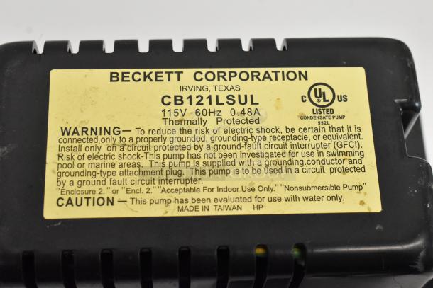 Beckett CB121LSUL pump, 115V, 60Hz, thermally protected. Label shows warnings and usage instructions. Made in Taiwan.