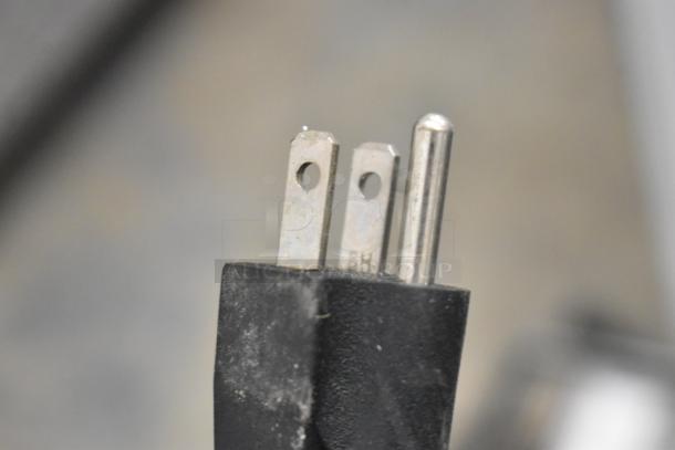 Close-up of a plug for the Vevor BQL-9200ST ice cream machine, showing a standard three-prong design.