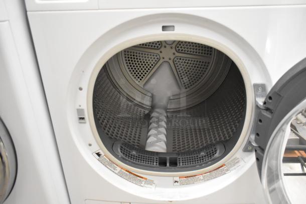 Whirlpool front load metal dryer, open door view, 120 volts, 1 phase. Clean interior, warning labels visible.