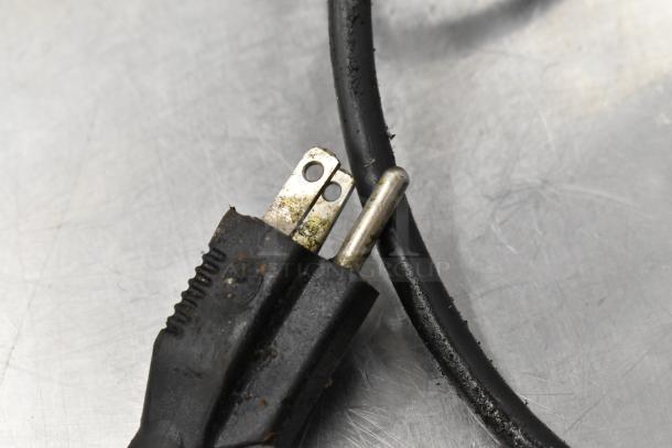 Plug and cable of a Blodgett stainless steel commercial gas-powered convection oven on a metal surface.