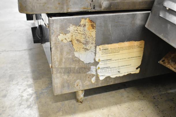 Radiance stainless steel commercial gas griddle with wear and peeling caution label, used condition.