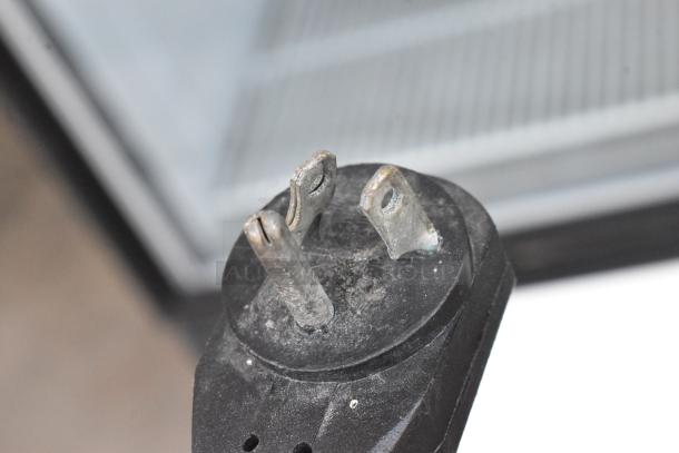 Power plug for True GDM-23F commercial single door freezer visible, highlighting electrical connection details.