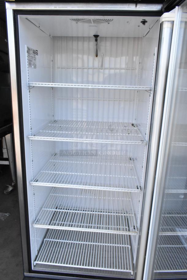 True GDM-23F metal commercial freezer with glass door, five poly coated racks; 115V, single phase. Tags indicate model and specs.