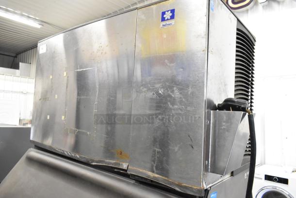 Manitowoc SY1405W stainless steel ice machine head on B970 bin. Features visible wear. 208-230V, 1 phase. Suitable for commercial use.