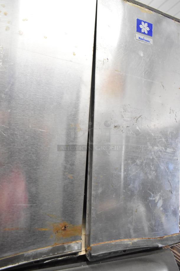 Manitowoc SY1405W stainless steel ice machine on B970 bin. 208-230V, 1 phase. Visible rust and wear. Manitowoc label.