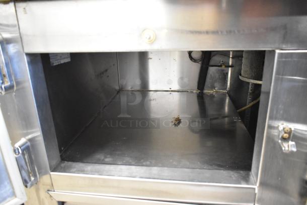 Leader 2 Door Undercounter Cooler, stainless steel interior, shows signs of wear, 115 volts, 1 phase.