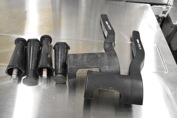 Bunn Slushie machine handles on stainless surface, showing used condition. No visible lids; check for hopper damage.