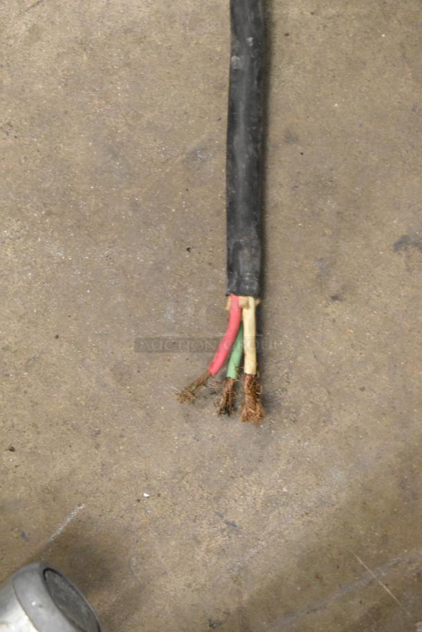 Frayed electrical cord with exposed wires next to a metal surface, indicating repair needed.