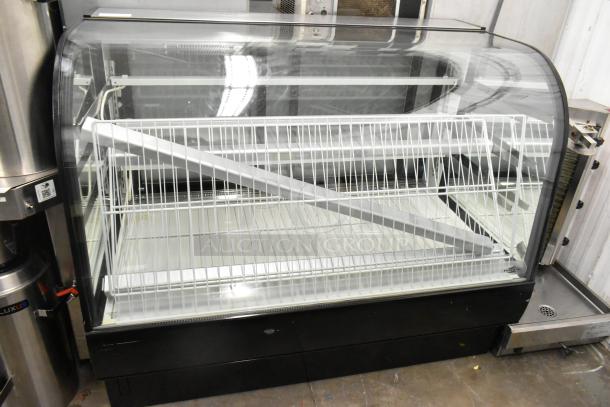 Metal commercial floor-style dry display case merchandiser with curved glass front, two-tier wire shelving, and black base.