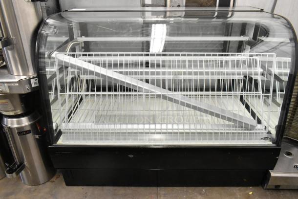 Metal commercial floor style dry display case merchandiser with clear curved glass, metal shelves, and black base, in good condition.