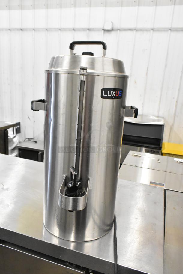 Stainless steel satellite server for Fetco CBS-62H coffee machine, marked with "LUXUS" label, on a metal countertop.