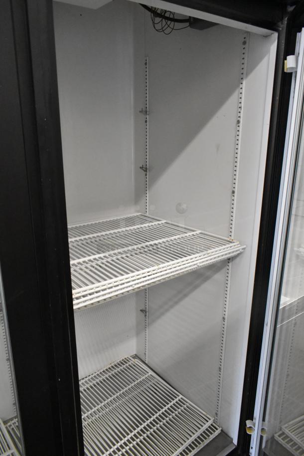True GDM-72 three-door reach-in cooler merchandiser with poly-coated racks, 115 volts, metal construction, excellent condition.