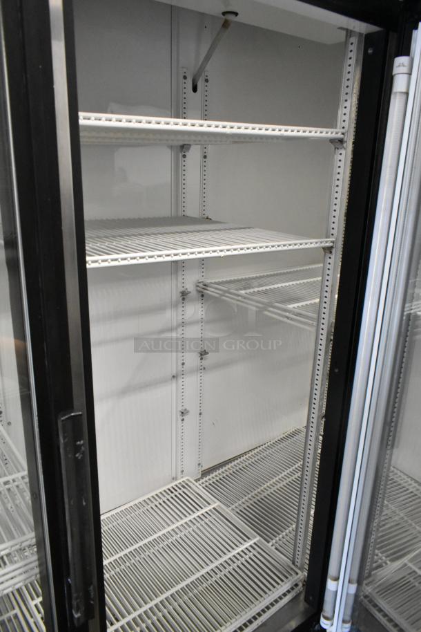 True GDM-72 metal commercial 3-door reach-in cooler with poly-coated racks, 115 volts, 1 phase, in good condition.