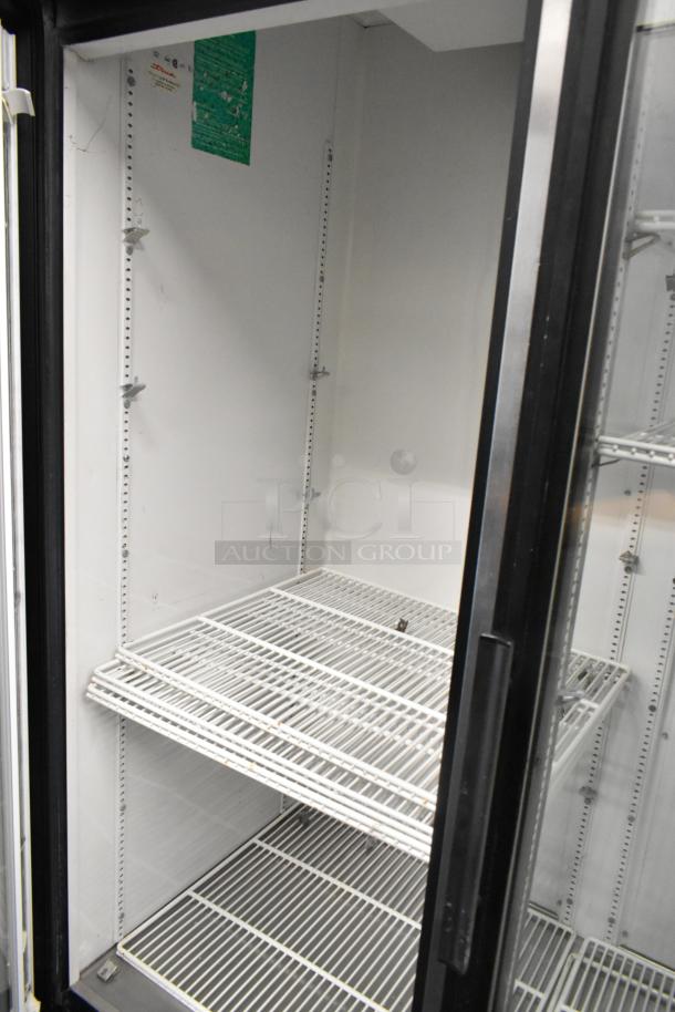 True GDM-72 metal commercial 3-door cooler with poly coated racks, visible tags, 115V, 1 phase, in used condition.
