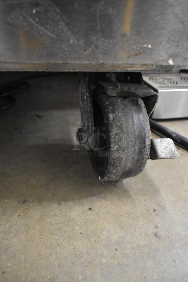 Beverage Air HBF49-1 commercial freezer caster with signs of wear on a concrete floor, showing mobility.