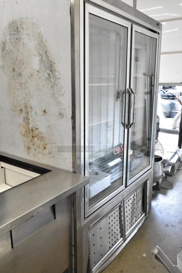 Leader PF54 SC 2-door cooler merchandiser with glass doors, poly-coated racks. Visible wear and rust on exterior. 230V, 1 phase.
