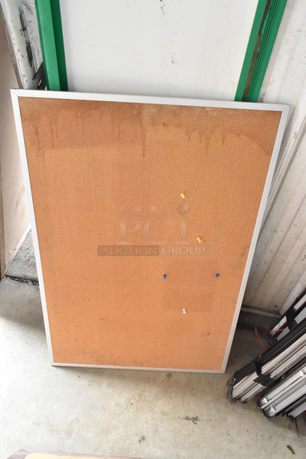 Framed cork board with a silver frame, featuring multicolored pins. Suitable for posting notes or pictures.
