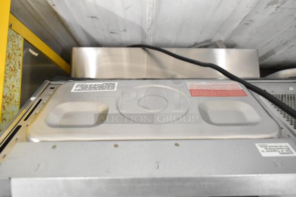 Sharp stainless steel commercial countertop microwave oven, top view. Note: handle broken, door cannot open.