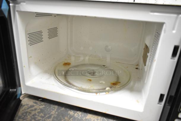 Hamilton Beach P90D23AL-WR microwave, stainless steel, interior shows some residue. 120 Volts, 1 Phase. Model P90D23AL-WR.