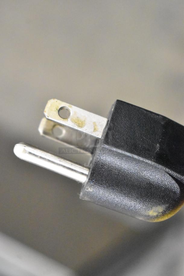 Close-up of a black electrical plug for a 2019 OY-828 Metal Countertop Popcorn Machine, 110 Volts, 1 Phase.