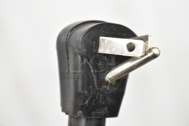 Close-up of black electrical plug tip for Amana RCS10TS microwave. Features standard prongs, minor wear visible.