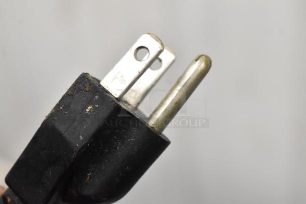 A close-up of a standard three-prong plug with some wear, typically used for electrical appliances.