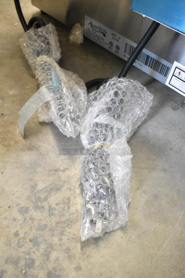 Brand new Avantco 177F102 stainless steel dual tank fryer, 20 lb. capacity, with tags and bubble wrap packaging visible.