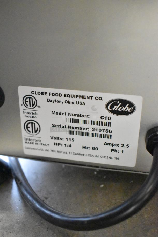 "Globe C10 metal commercial meat slicer, features blade sharpener. Brand new with minor scratches. 115 volts, model info tag visible."