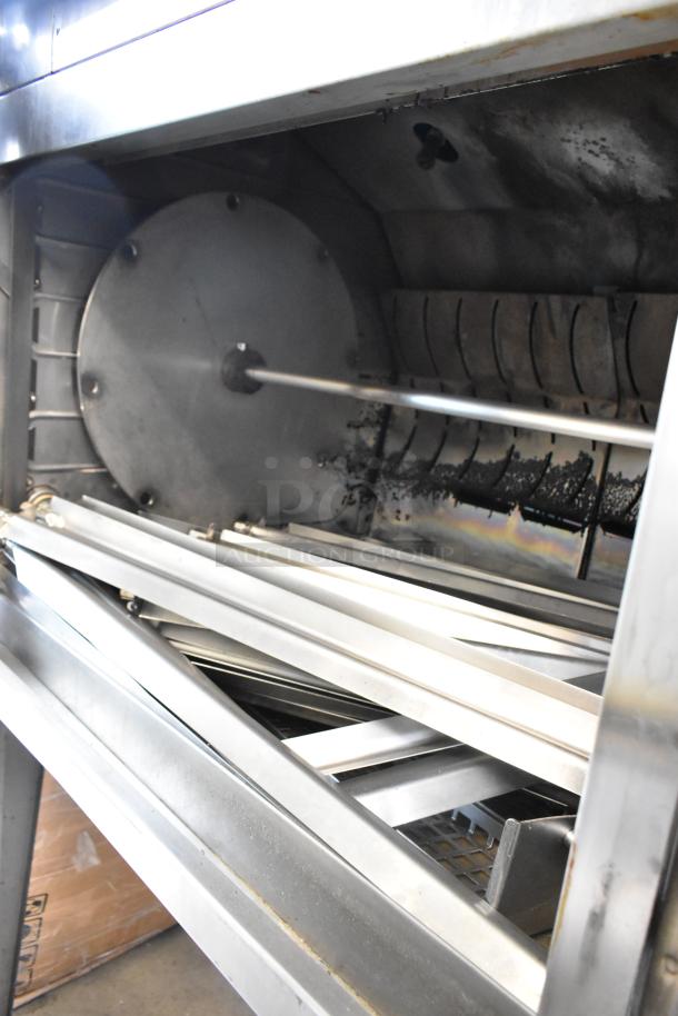 Hardt Inferno 4500 stainless steel rotisserie oven with skewers, natural gas powered, on metal legs, interior view.