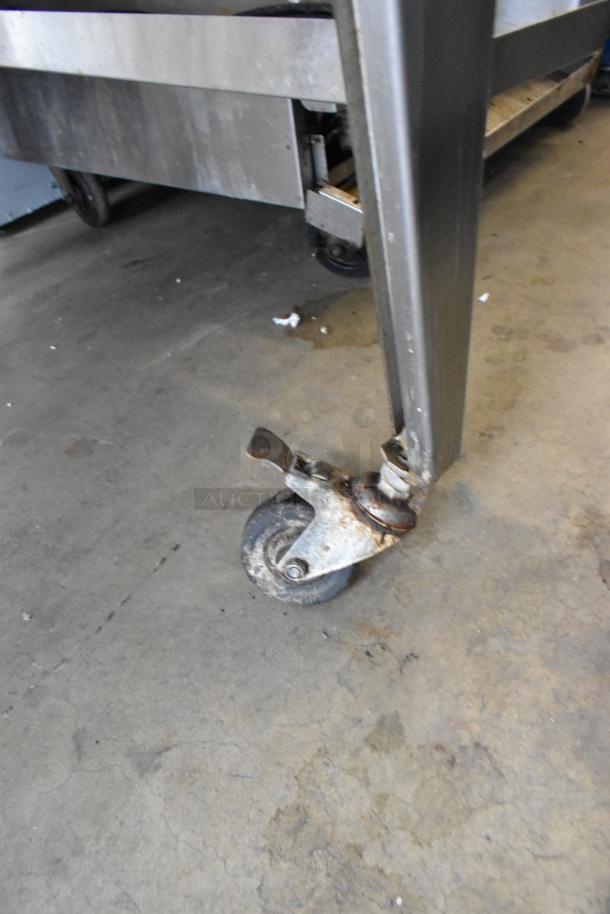 Hardt Inferno 4500 rotisserie oven leg and caster detail, showing stainless steel construction and wear on the wheel.