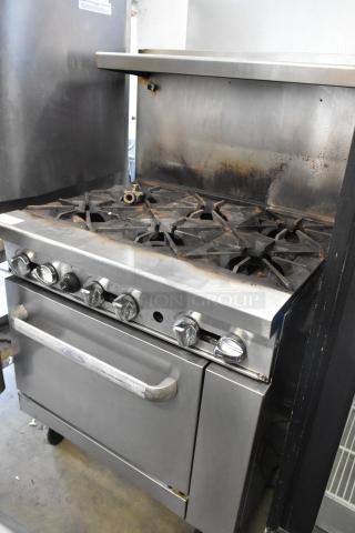 Stainless steel commercial 6-burner gas range with oven, overshelf, backsplash, and commercial casters. Slightly used.