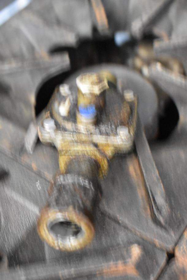 Blurry image showing part of a commercial gas range burner. Visible wear and rust suggest used condition.