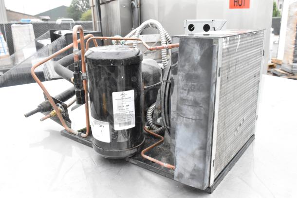 Copeland M4FHCA036-IAA-045 compressor, 115/208-230V, 1 phase, labeled, mounted on frame, visible copper piping.