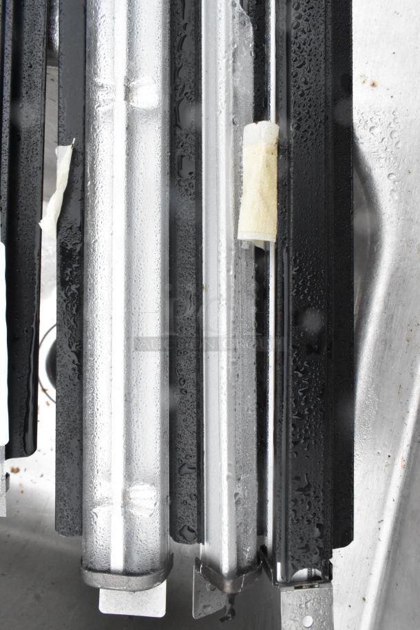 Set of five fluorescent lights, in good condition, arranged side by side. Clear tubes with metal end caps.