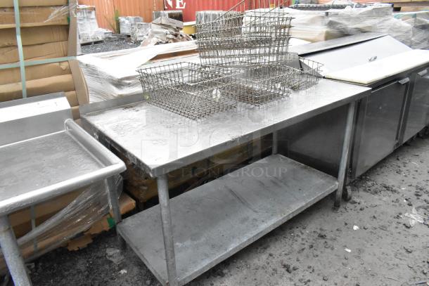Stainless steel table with under shelf, includes metal baskets. Used condition, ideal for commercial kitchen setup.