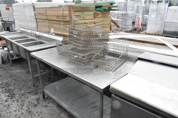 Stainless steel table with metal under shelf, includes metal baskets. Used condition, suitable for industrial use.