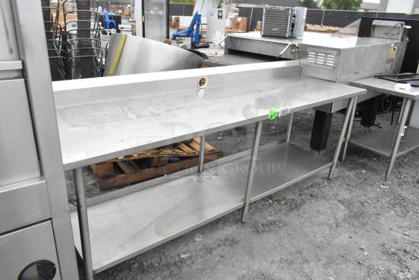 Stainless steel table with under shelf and back splash in good condition, suitable for kitchen use.